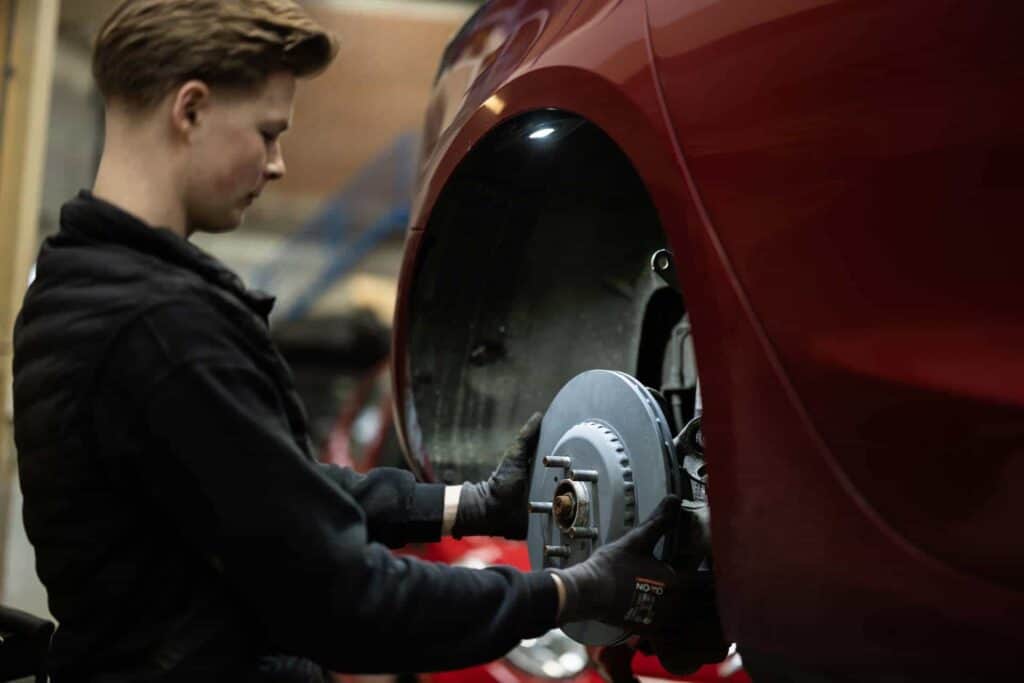 Tesla mekaniker i færd med udskiftning af hjul på Tesla værksted