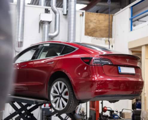 Rød Tesla i Tesla værksted