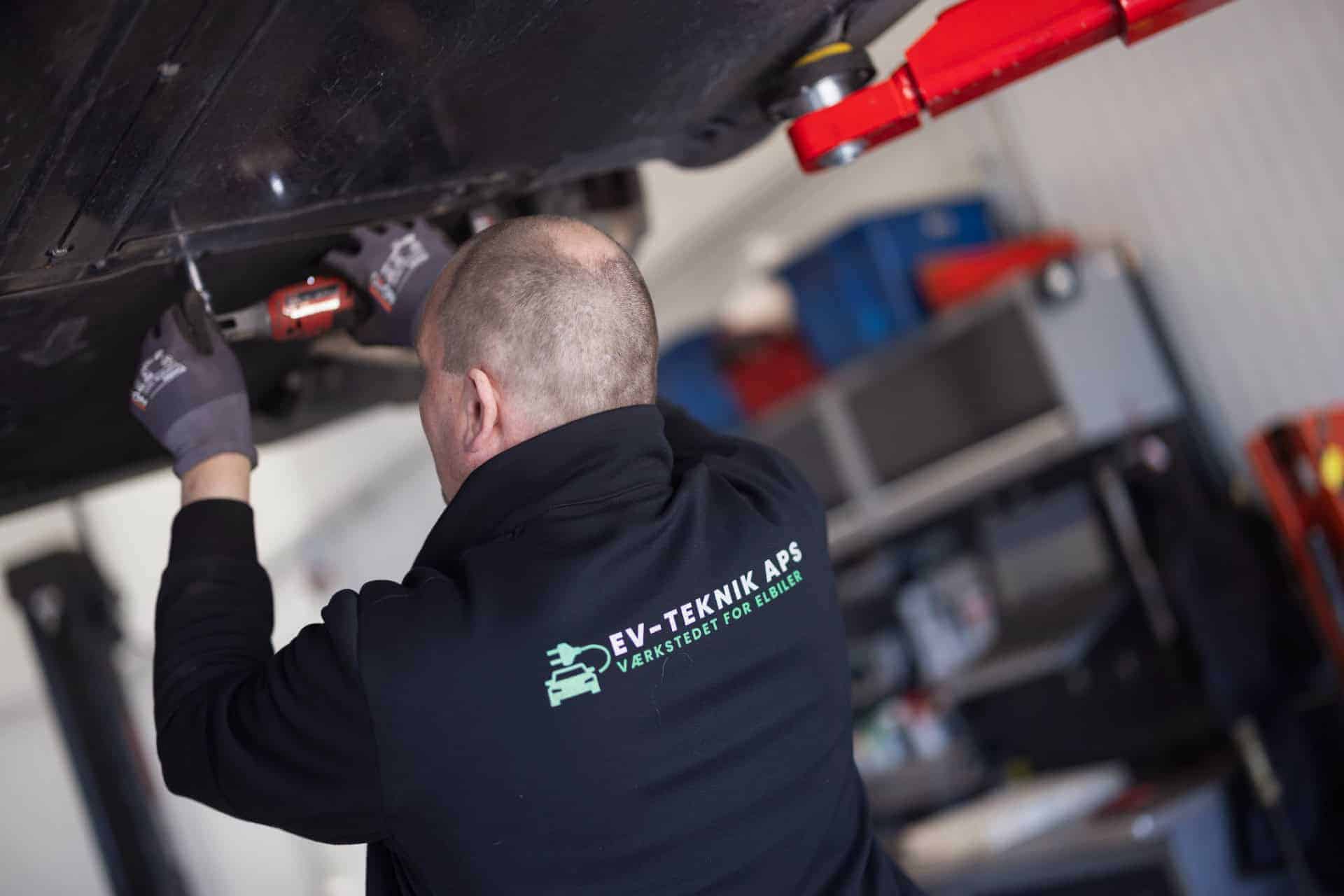Mekaniker arbejder under elbil på lift - "EV-TEKNIK APS"